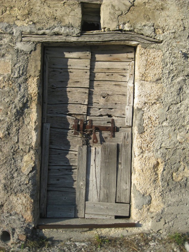 Old wooden door of an abandoned stall in Castelluccio