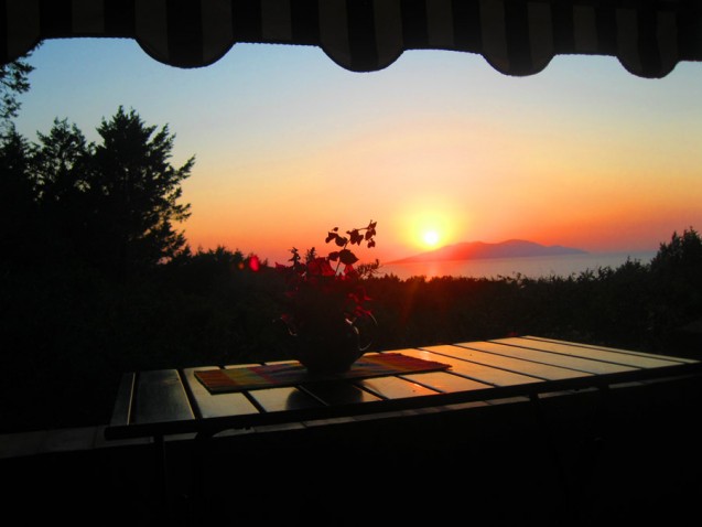 The-setting-sun-drops-into-the-sky-behind-Giglio---view-from-terrace